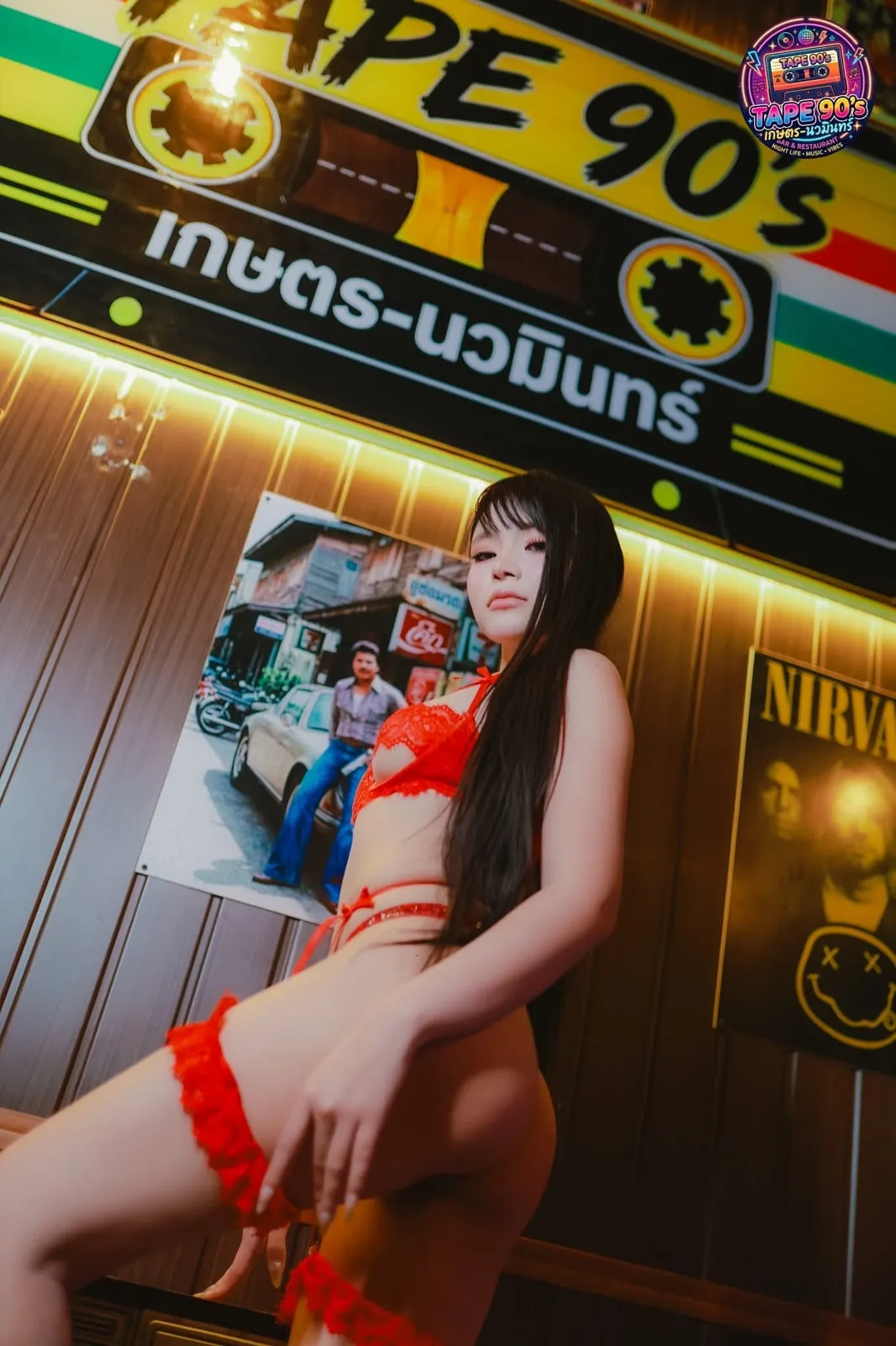 Người mẫu nội y đỏ trước biển đèn của quán