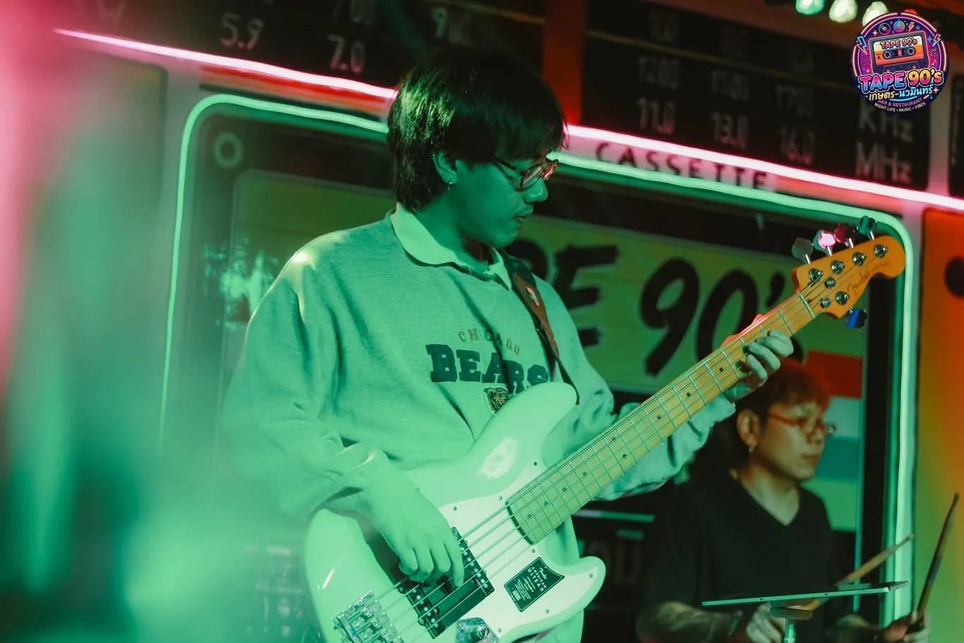 Tay bass chơi đàn dưới ánh đèn xanh